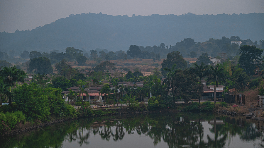 A serene view of a lake surrounded by trees and hills in the background at Lotus Leaf Boutique Hotel.