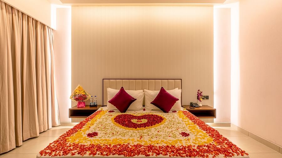 An image of a bed decorated with flower petals, featuring a heart shape in the center and an abundance of petals scattered around the sides at M Pro Palace.