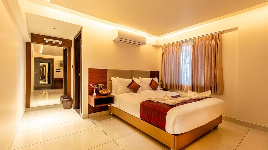 An image of a room with a bed and an open door on the side at M Pro Palace.