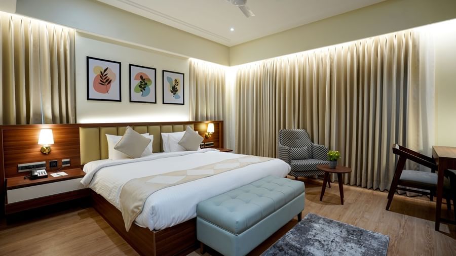 Full view of the Superior King Bed Room featuring a king size bed along with a cushioned bench in placed in front of it at M2 Square by Monday Premium.