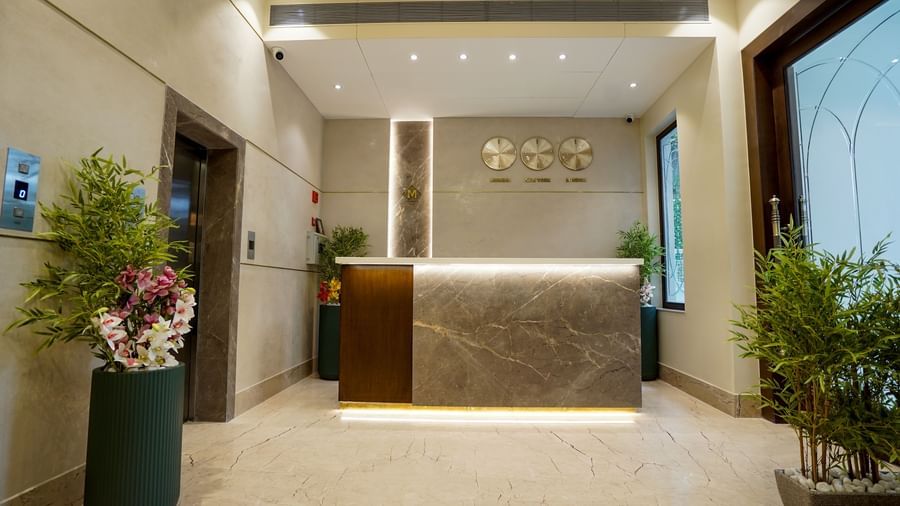 Front view of the lobby featuring a reception desk with three clocks hung on the wall at M2 Square by Monday Premium.