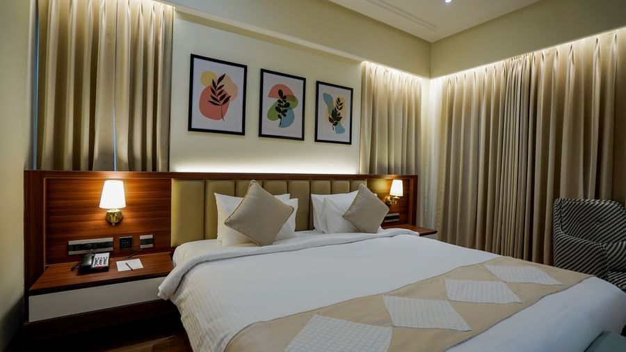 Corner view of the Superior King Bed Room with a false ceiling along with thick beige curtains in the room at M2 Square by Monday Premium.