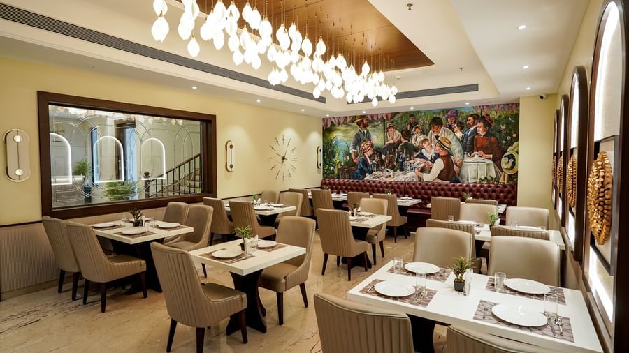 A wide angle shot of the Mosaic restaurant featuring a brightly lit dining area with modern interiors and well arranged tables at M2 Square by Monday Premium.