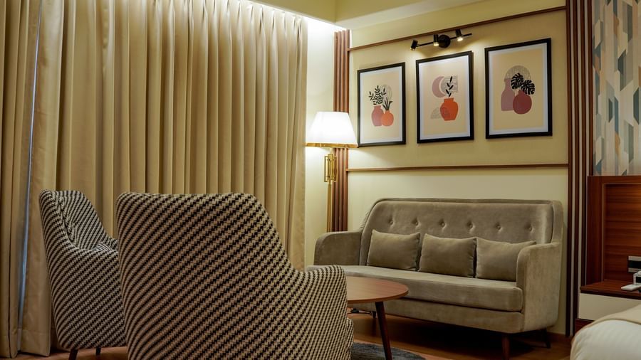 A close-up shot of the separate seating area with a tall lamp in the corner in the premium room at M2 Square by Monday Premium.