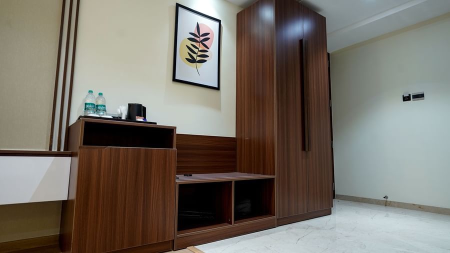 A wooden wardrobe along with a luggage rack and a utility area at the Superior King Bed Room at M2 Square by Monday Premium.