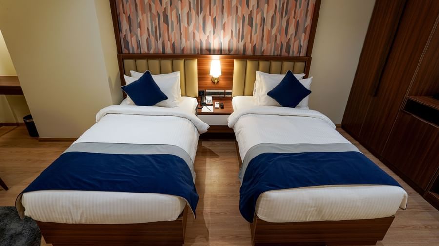 Top angle shot of the twin beds along with a bed side table in the middle at the Superior Twin Bed Room at M2 Square by Monday Premium.
