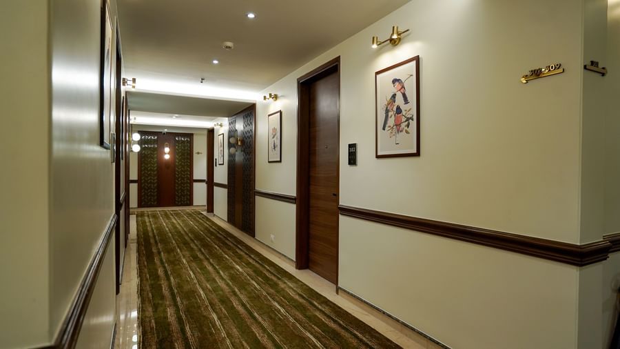A wide angle shot of the dimly-lit corridor with several doors leading to the rooms at M2 Square by Monday Premium.