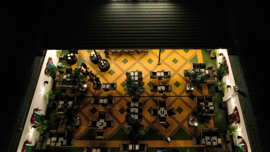 Aerial view of the Sky Roof during the night featuring a brightly lit dining area at M2 Square by Monday Premium.