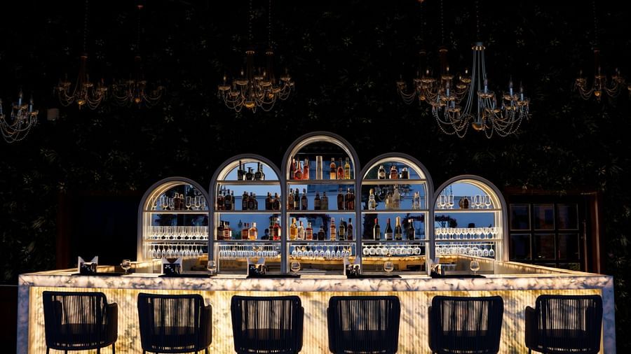 Front view shot of the bar counter at Sky Roof featuring 6 elevated chairs placed along side the bar counter at M2 Square by Monday Premium.