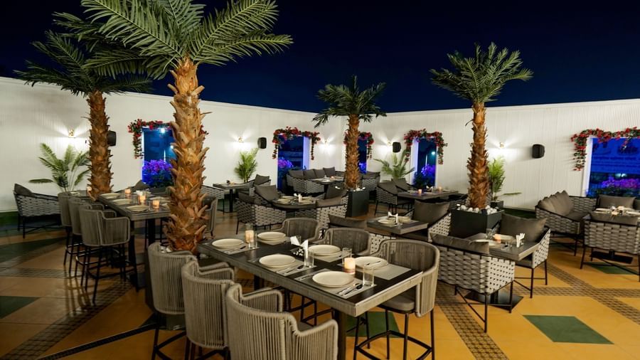 Corner view shot of the Sky Roof featuring well arranged dining tables along side several trees at M2 Square by Monday Premium.