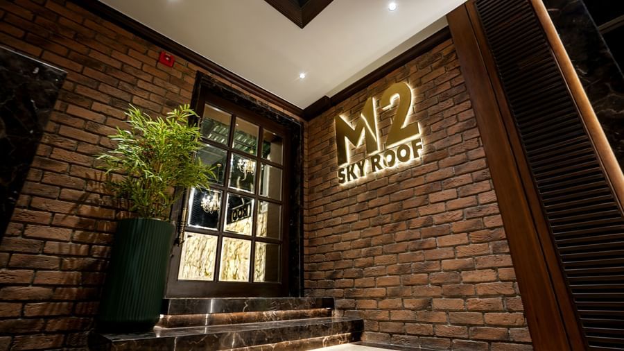 Entrance of the Sky Roof at M2 Square by Monday Premium with a back-lit signboard mounted on a bricked wall.