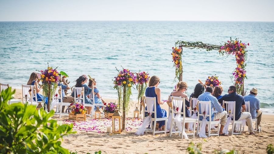 A group of people seated in the wedding setup waiting for the ceremony to begin at maikhao dream villa resort & spa, phuket 