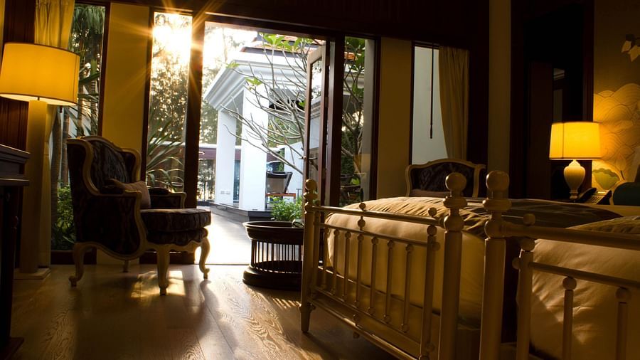 A bedroom with twin beds showcasing a bright sun outside the room - two bedroom private pool beachfront villa
