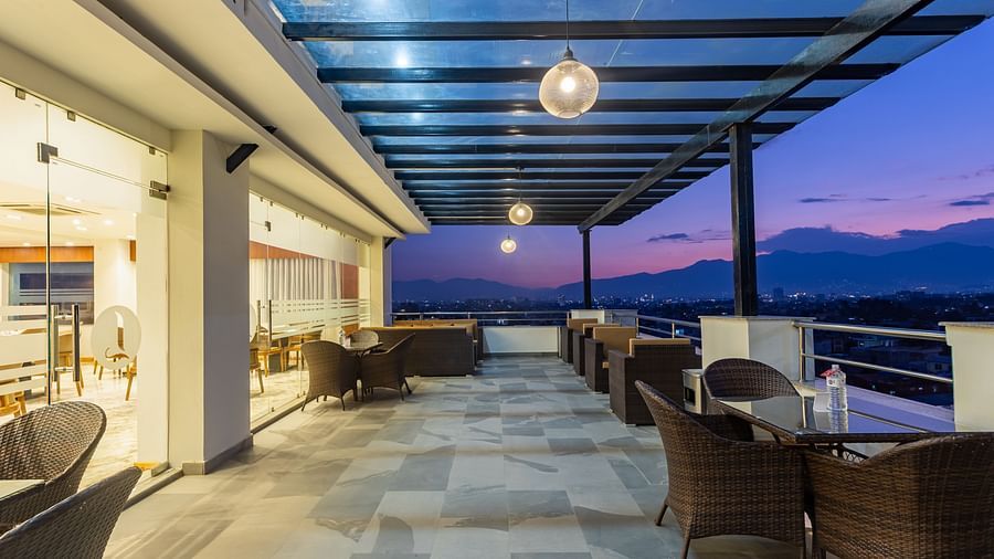 Outdoor seating arrangement at Mandala by Lords featuring a spacious corridor with a covered ceiling and picturesque views.