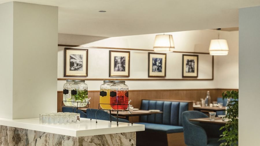 A dining area at Mango Hill Central, Chennai, with booths and a white counter in the foreground. There are framed pictures on the wall.