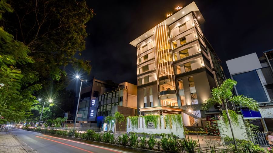 An exterior night view of Mango Hill Central, Chennai, showing the hotel building and the street in front of it.