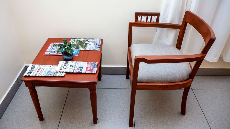 A table and a chair placed at one corne of a room | Mango Hill La Serene, Pondicherry