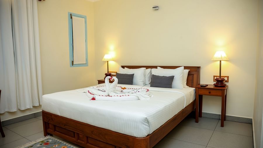 A bedroom which has a bed decorated by towel swans | Mango Hill La Serene, Pondicherry