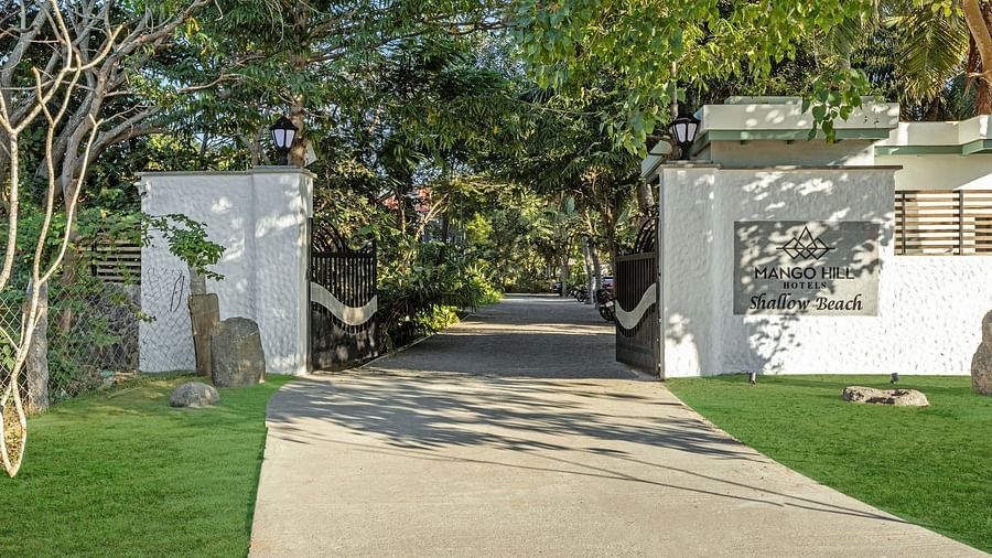 Resort entrance gate with a pathway leading through lush greenery to the Pondicherry wedding resorts | Mango Hill Shallow Beach Resort ECR