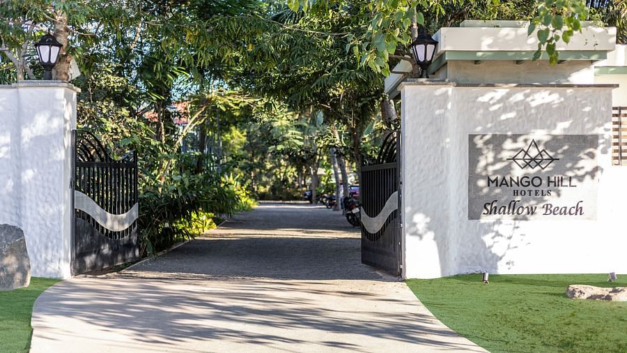 Entrance to a resort with a pathway leading through lush greenery | Mango Hill Shallow Beach Resort ECR