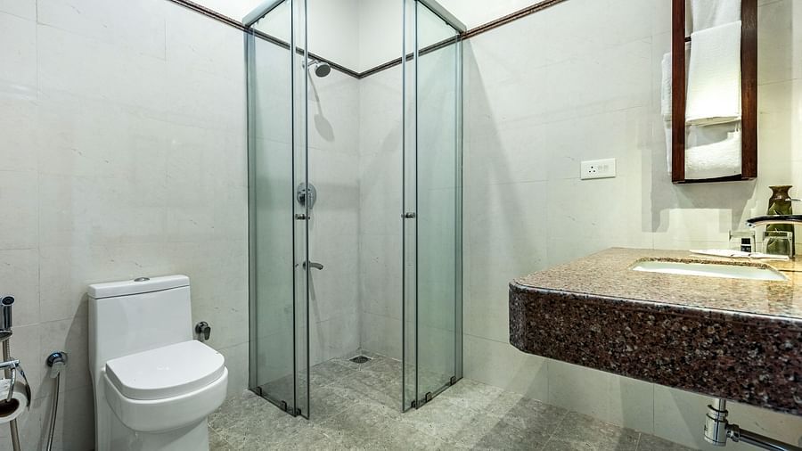 Bathroom with a glass shower enclosure, toilet, and granite countertop sink | Mango Hill Shallow Beach Resort ECR