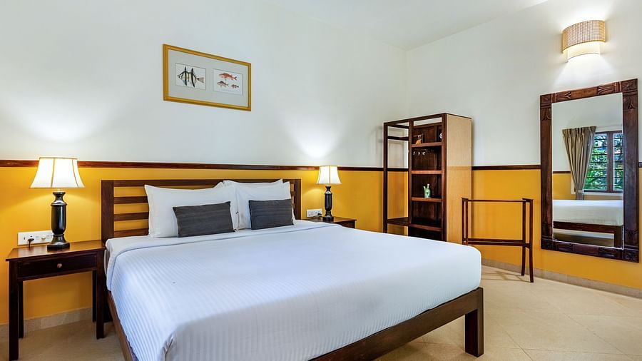  Bedroom with a double bed, nightstands, lamps, a mirror, and a shelving unit | Mango Hill Shallow Beach Resort ECR