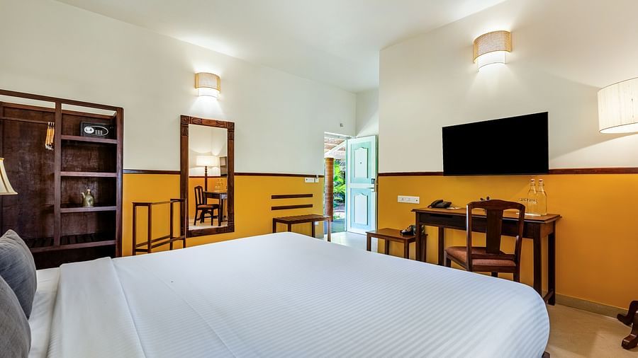 A close up shot of the room in Pondicherry featuring a king size bed, television, work desk | Mango Hill Shallow Beach Resort ECR