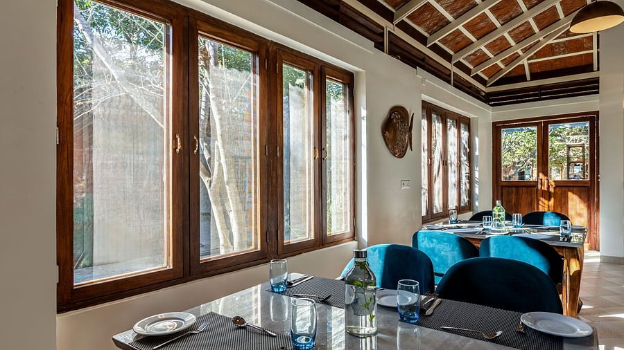 Restaurant interior with set tables, large windows, and a high, patterned ceiling | Mango Hill Shallow Beach Resort ECR