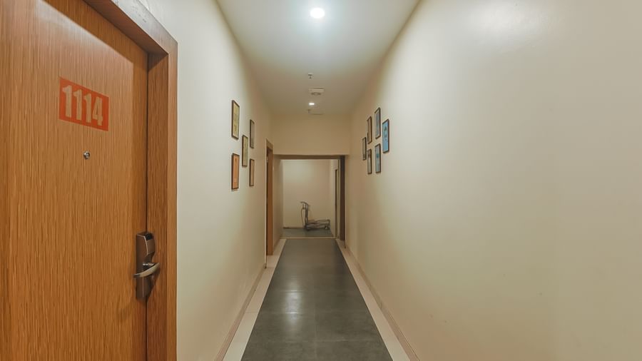 Corridor with beige walls, doors and lighting inside Max Hotel Prayagraj.