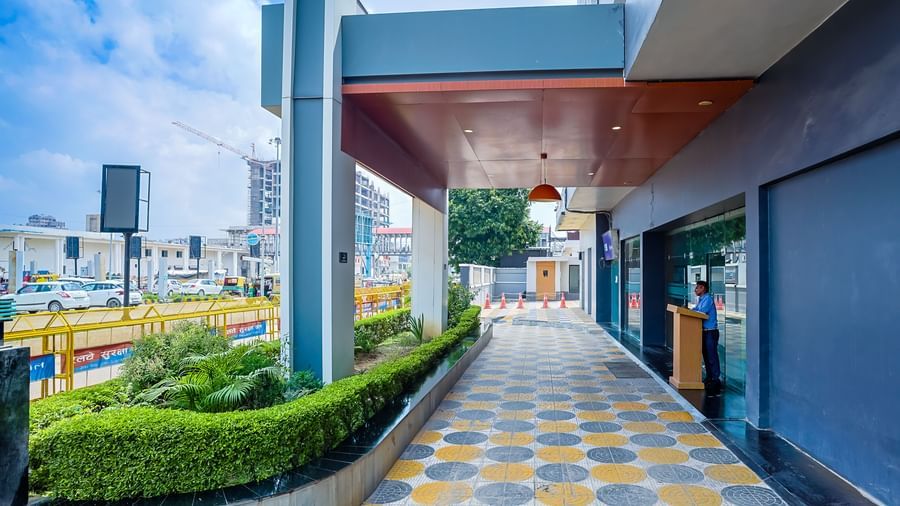 Entrance walkway with patterned tiles and greenery at Max Hotel Prayagraj.