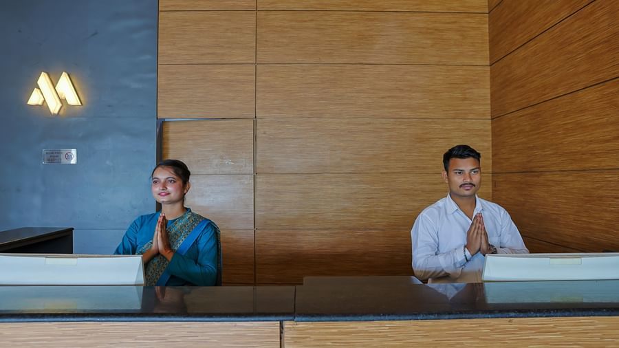 Reception desk with staff members at Max Hotel Prayagraj.