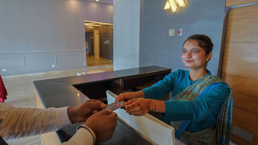 Guest sitting area with staff handing a document at Max Hotel Prayagraj.