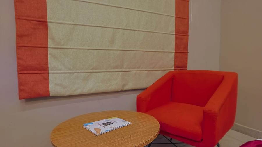Small corner seating with red chairs and table at Max Hotel Prayagraj.