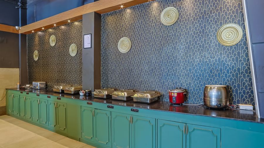 Buffet setup with utensils, chafing dishes and counters at Max Hotel Prayagraj.