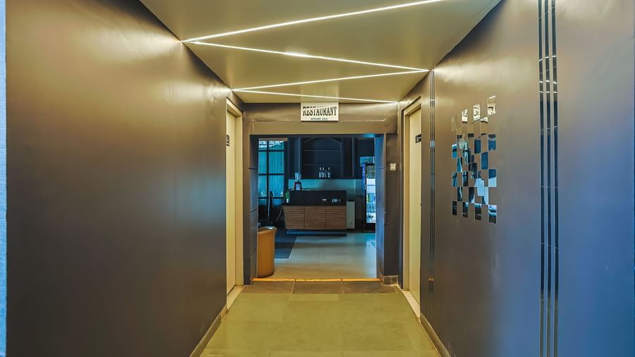 Corridor with modern ceiling lights and wall decor at Max Hotel Prayagraj.
