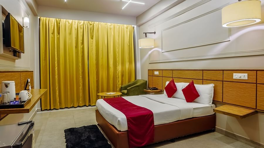 Room with bright curtains and double bed at Max Hotel Prayagraj.