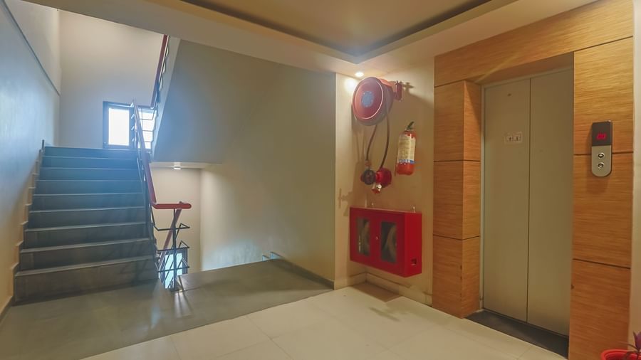 Staircase area with fire safety equipment at Max Hotel Prayagraj.