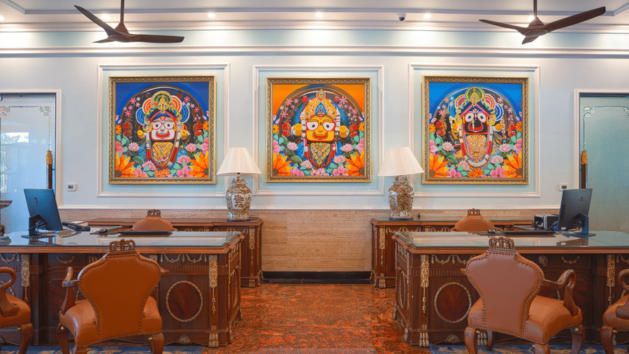 Front office lobby featuring three traditional artworks, wooden desks, and dark seating at MAYFAIR Bay Resort, Paradeep.