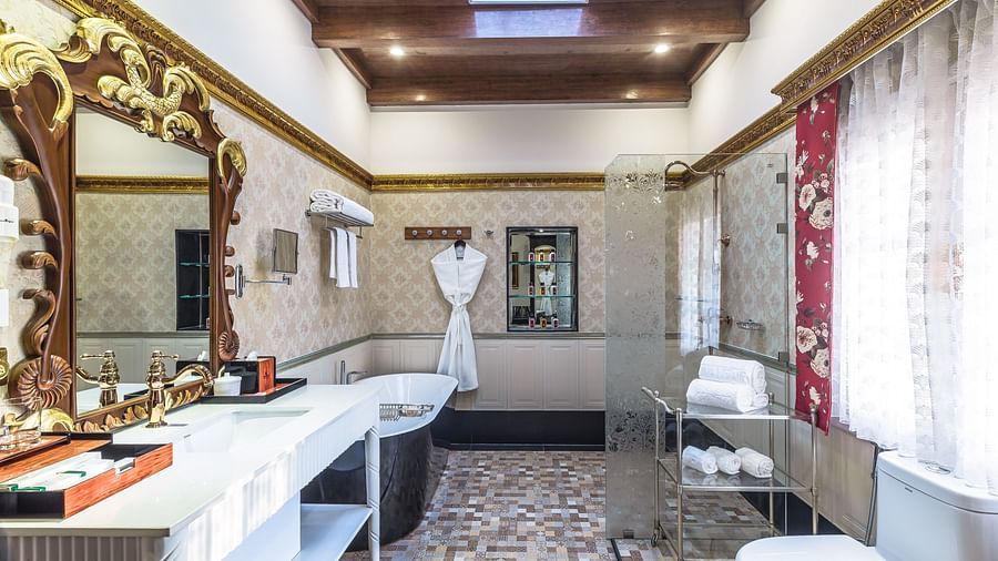 a bathroom offering a wash basin on the left side and a bathrobe hanging on one side - Mayfair Himalayan Spa Resort Kalimpong