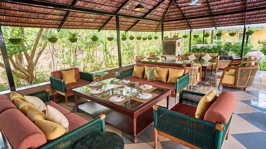 A cluster of cushioned sofas around the table, creating a lounging area at Mayfair Manor, Alibag