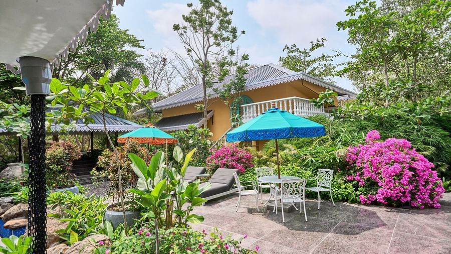 The exterior view of Mayfair Manor, Alibag, framed by trees and plants surrounding the property