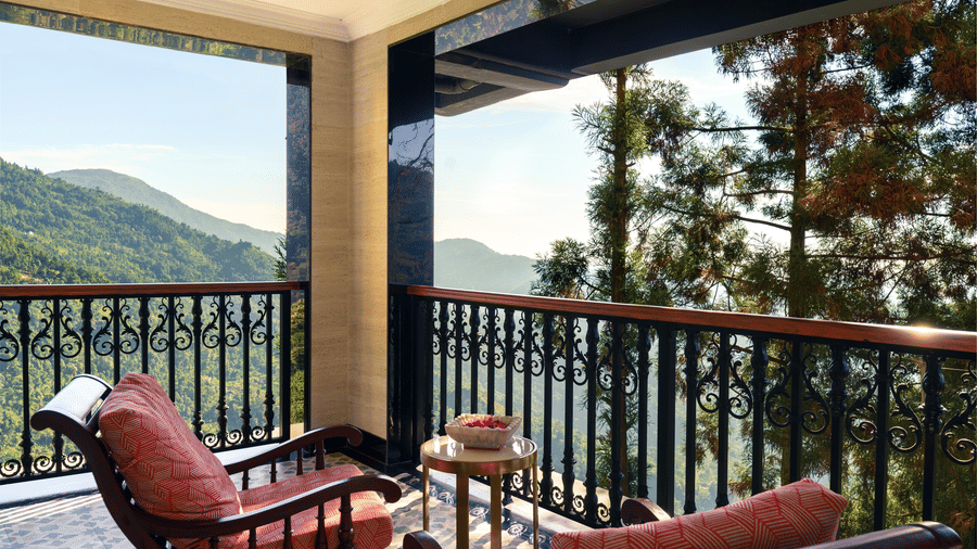 Spacious balcony seating area overlooking lush valley hills at Mayfair Manor, Jungpana.