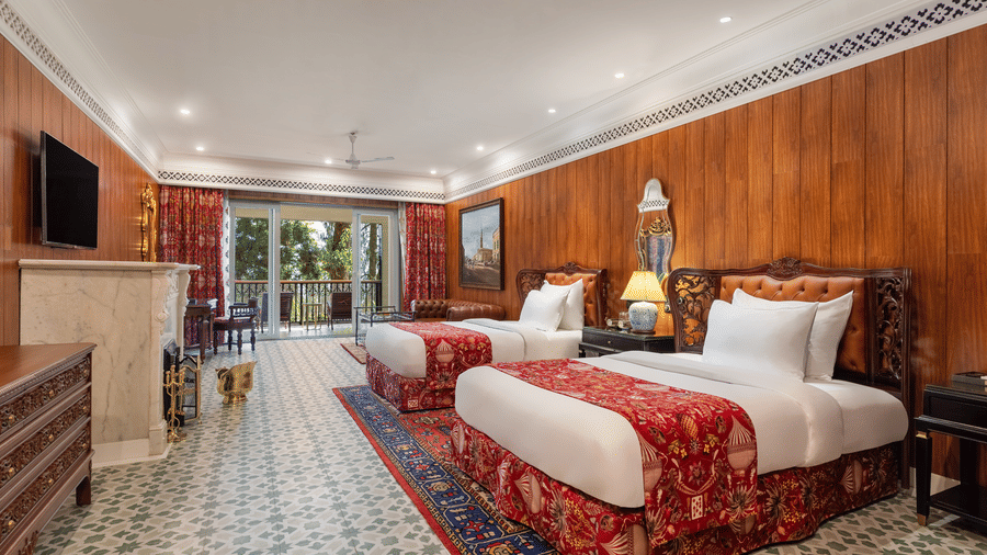 Spacious heritage bedroom with twin beds and wooden panelling at Mayfair Manor, Jungpana.