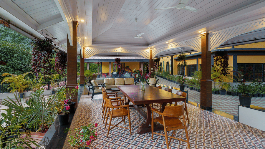Covered outdoor verandah dining area overlooking garden plants at Mayfair Manor, Jungpana.