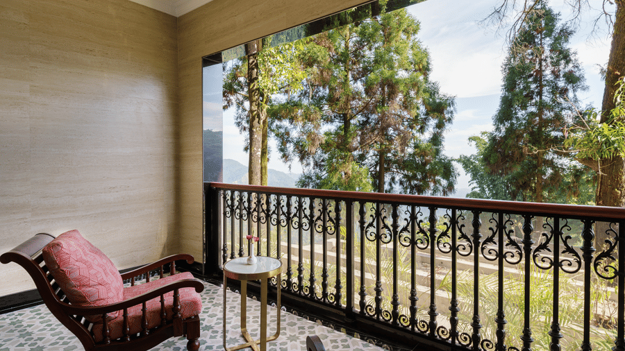 Private balcony with seating overlooking surrounding trees and hills at Mayfair Manor, Jungpana.