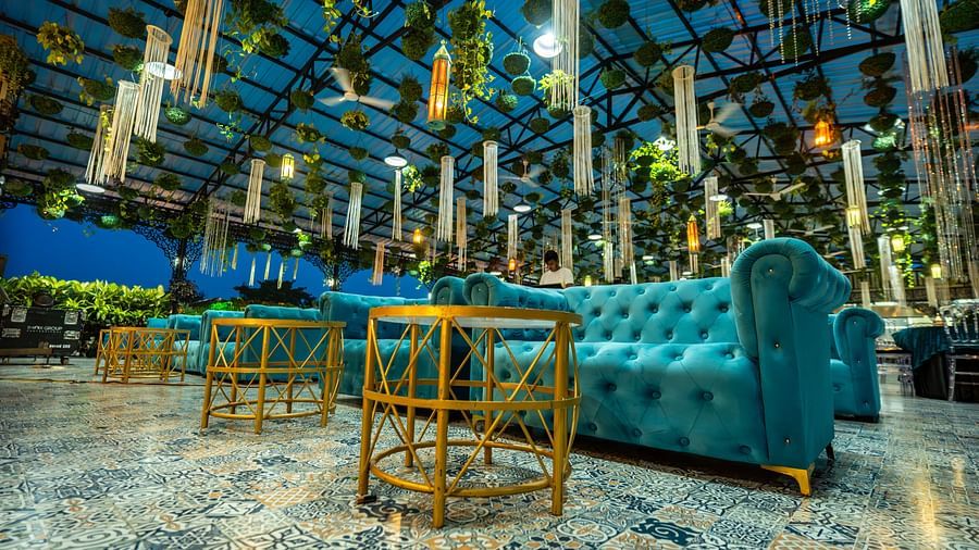 A gold coloured table and blue sofa at Mayfair Purnea