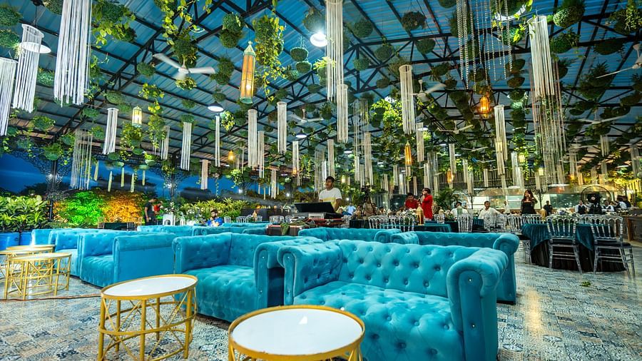 A gold coloured table and blue sofa at Mayfair Purnea