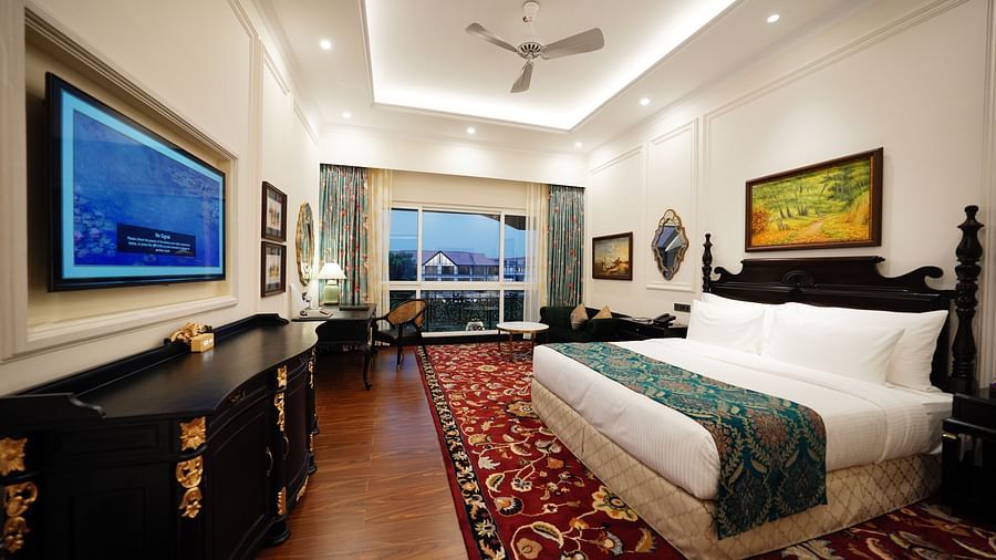 Contemporary suite with teal beds, flat-screen TV, and modern lighting.