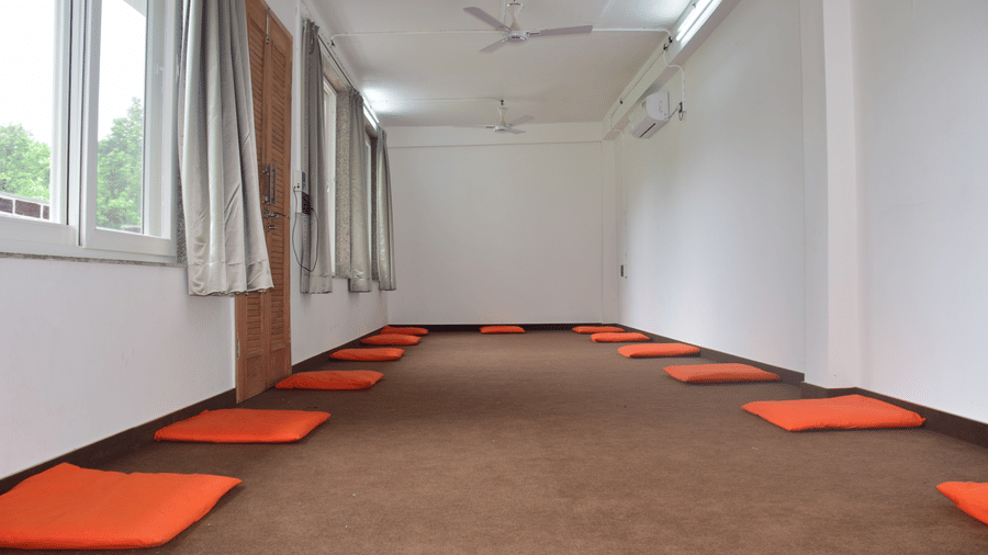 Spacious indoor yoga hall with floor mats neatly arranged for practice - Megha Resort & Villas, Dehradun