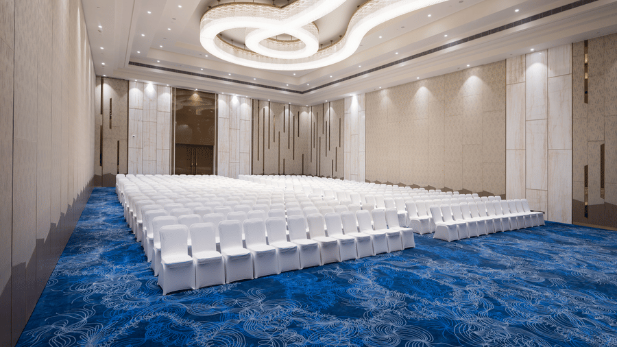 Elegant banquet hall with modern ceiling lights and theatre-style seating at Mirai Ballroom Hall inside Merlis Hotel, Coimbatore.
